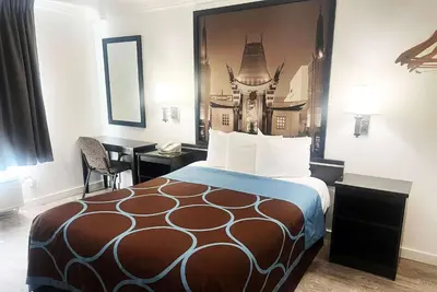 a hotel room with a bed and a desk at Super 8 by Wyndham Hollywood/LA Area in Los Angeles