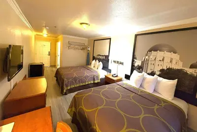 a hotel room with two beds and a television at Super 8 by Wyndham Hollywood/LA Area in Los Angeles