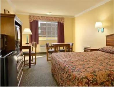 a hotel room with a bed and a table at Super 8 by Wyndham Los Angeles Downtown in Los Angeles