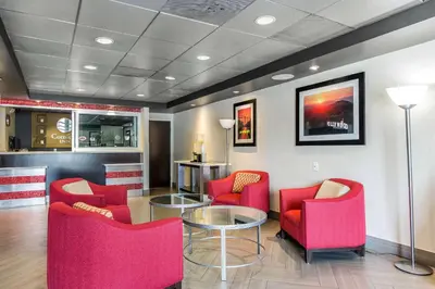 a waiting room with red chairs and a glass table at Comfort Inn Los Angeles near Hollywood in Los Angeles
