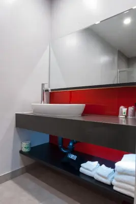 a bathroom with a sink and towels on a shelf at Astro Pasadena Hotel in Pasadena