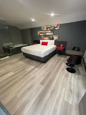 a bedroom with a bed and a bathroom with a tub at Astro Pasadena Hotel in Pasadena