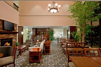a lobby with tables and chairs and a fireplace at Staybridge Suites Palmdale by IHG in Palmdale