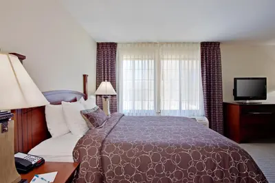 a hotel room with a bed and a television at Staybridge Suites Palmdale by IHG in Palmdale