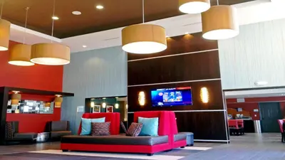 a lobby with a couch and a tv on a wall at Holiday Inn Express Bakersfield by IHG in Bakersfield