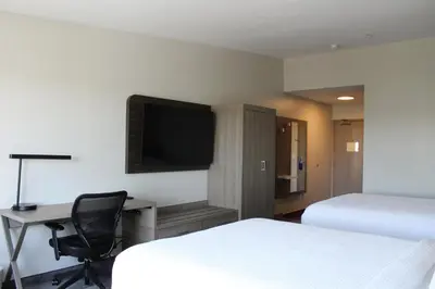 a hotel room with two beds and a desk and a tv at Holiday Inn Express Bakersfield by IHG in Bakersfield