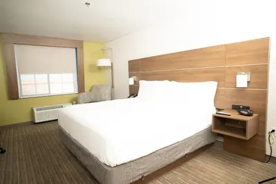 a bedroom with a large white bed and a window at Holiday Inn Express Hotel & Suites Hesperia by IHG in Hesperia