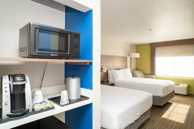 two pictures of a hotel room with a bed and a tv at Holiday Inn Express Hotel & Suites Hesperia by IHG in Hesperia