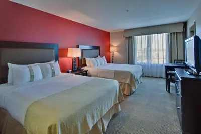a hotel room with two beds and a flat screen tv at Holiday Inn & Suites Bakersfield by IHG in Bakersfield