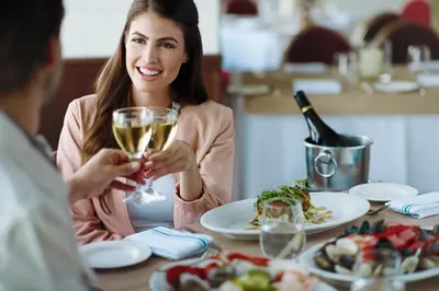 a woman sitting at a table with a glass of wine at The Queen Mary in Long Beach