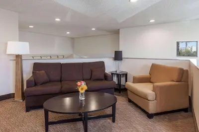 a living room with a couch and two chairs and a table at Baymont by Wyndham Barstow Historic Route 66 in Barstow