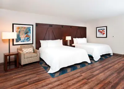 a hotel room with two beds and a chair at Hilton Garden Inn Burbank Los Angeles in Burbank