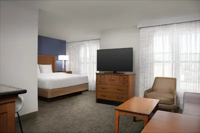 a hotel room with a bed and a flat screen tv at Residence Inn by Marriott San Bernardino in San Bernardino