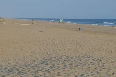 a sandy beach with a volleyball court and the ocean at Seaside Inn Motel in Port Hueneme