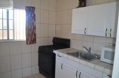 a small kitchen with a stove and a sink at Seaside Inn Motel in Port Hueneme