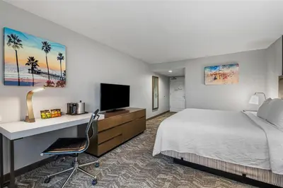 a hotel room with a bed and a desk with a television at Best Western Valencia/Six Flags Inn & Suites in Santa Clarita