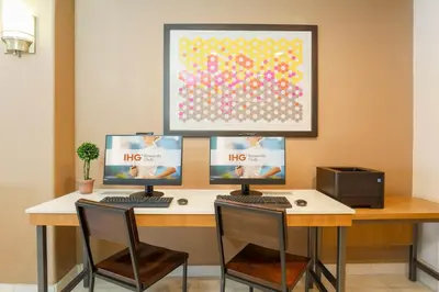 a desk with three computer monitors on top of it at Holiday Inn Express Lancaster by IHG in Lancaster