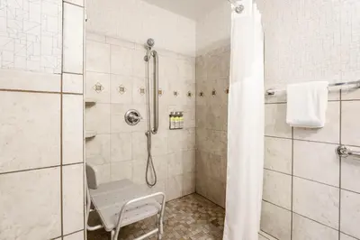 a bathroom with a shower with a bench in it at Holiday Inn Express Lancaster by IHG in Lancaster