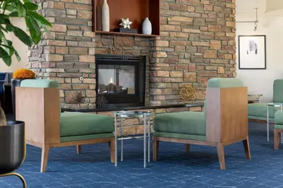a lobby with two chairs and a fireplace at Courtyard by Marriott Ontario Rancho Cucamonga in Rancho Cucamonga