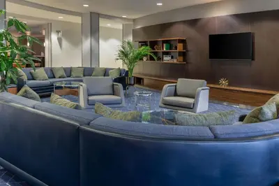 a lobby with a large blue couch and chairs at Courtyard by Marriott Ontario Rancho Cucamonga in Rancho Cucamonga