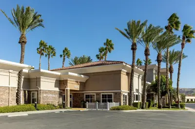a building with palm trees in front of it at Residence Inn by Marriott Corona Riverside in Corona