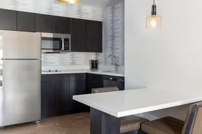 a kitchen with a white refrigerator and wooden cabinets at Residence Inn by Marriott Corona Riverside in Corona