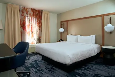 a hotel room with a bed and a chair at Fairfield Inn and Suites San Bernardino in San Bernardino