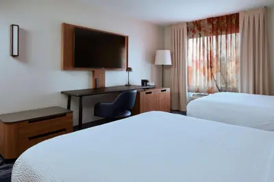 a hotel room with two beds and a desk with a computer at Fairfield Inn and Suites San Bernardino in San Bernardino