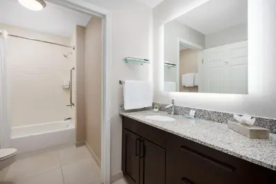 a bathroom with a sink and a toilet and a mirror at Residence Inn by Marriott Palmdale Lancaster in Palmdale