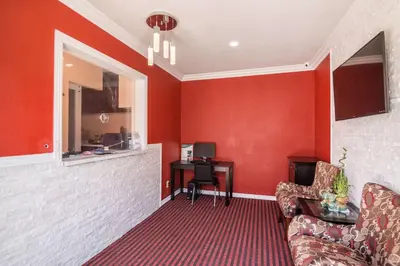 a red room with a couch and a desk at El Dorado Inn in Lynwood