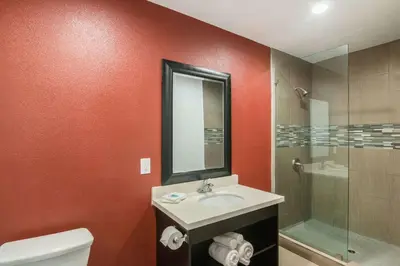 a bathroom with a sink and a glass shower at El Dorado Inn in Lynwood