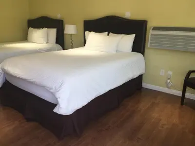 two beds with white sheets and pillows in a room at El Royale Hotel - Near Universal Studios Hollywood in Los Angeles