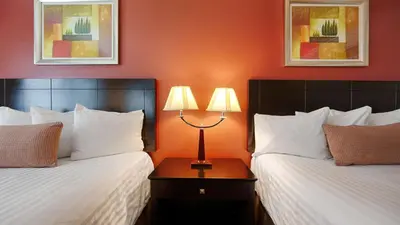 a hotel room with two beds and a lamp on a table at Best Western Burbank Airport Inn in Los Angeles
