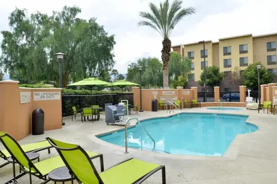 a pool at a hotel with chairs and tables at SpringHill Suites by Marriott Corona Riverside in Corona
