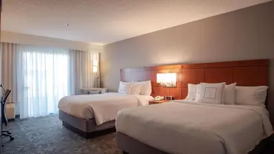 a hotel room with two beds and a large window at Sonesta Select Camarillo in Camarillo