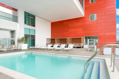 a swimming pool in a building with a red wall at Courtyard by Marriott Santa Monica in Los Angeles