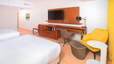 a hotel room with a bed and a desk with a television at Courtyard by Marriott Santa Monica in Los Angeles
