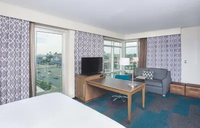 a hotel room with a bed and a desk and a television at Hampton Inn & Suites LAX El Segundo in El Segundo