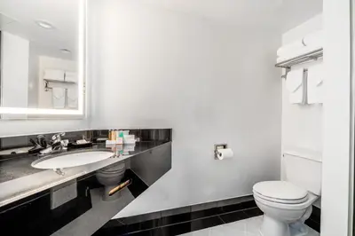 a bathroom with a toilet and a sink at Century Park Hotel LA in Los Angeles
