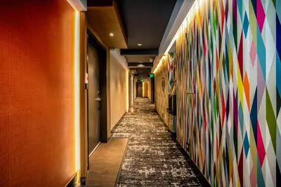 a hallway with a wall covered in colorful wallpaper at Century Park Hotel LA in Los Angeles