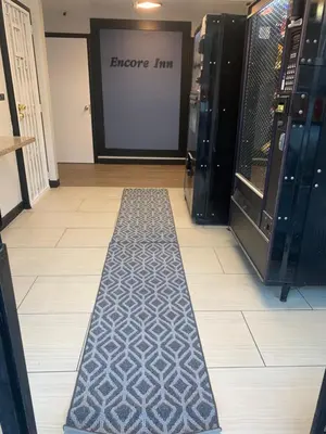 a floor with a black and white carpet in front of a door at Encore Inn Inglewood in Inglewood