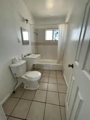 a white bathroom with a toilet and a sink at Encore Inn Inglewood in Inglewood