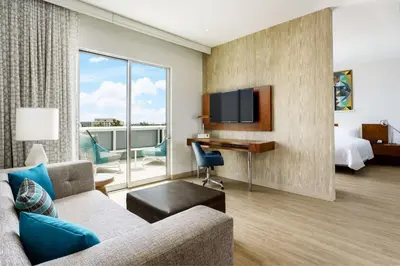 a hotel room with a couch and a bed and a desk at Hampton Inn & Suites Santa Monica in Los Angeles