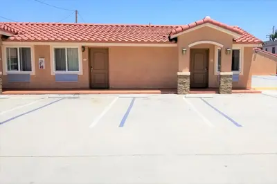 a house with a parking lot at Diamond Bell Inn & Suites in Bell