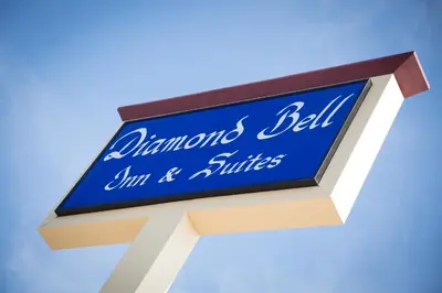 a blue sign for a dominos bell inn and suites at Diamond Bell Inn & Suites in Bell