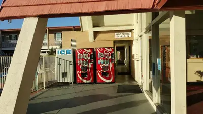 two cocacola pepsi machines on the side of a building at Willow Tree Lodge in Fullerton