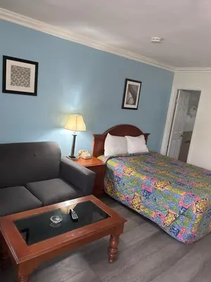 a bedroom with a bed and a couch and a coffee table at Willow Tree Lodge in Fullerton