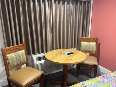 a room with a table and two chairs and a window at Willow Tree Lodge in Fullerton