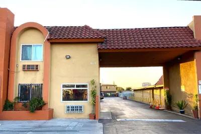 a large building with a garage with a driveway at Robinhood Motel Anaheim West in Anaheim