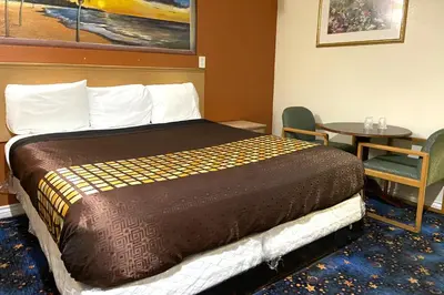 a hotel room with a bed and a table at Robinhood Motel Anaheim West in Anaheim